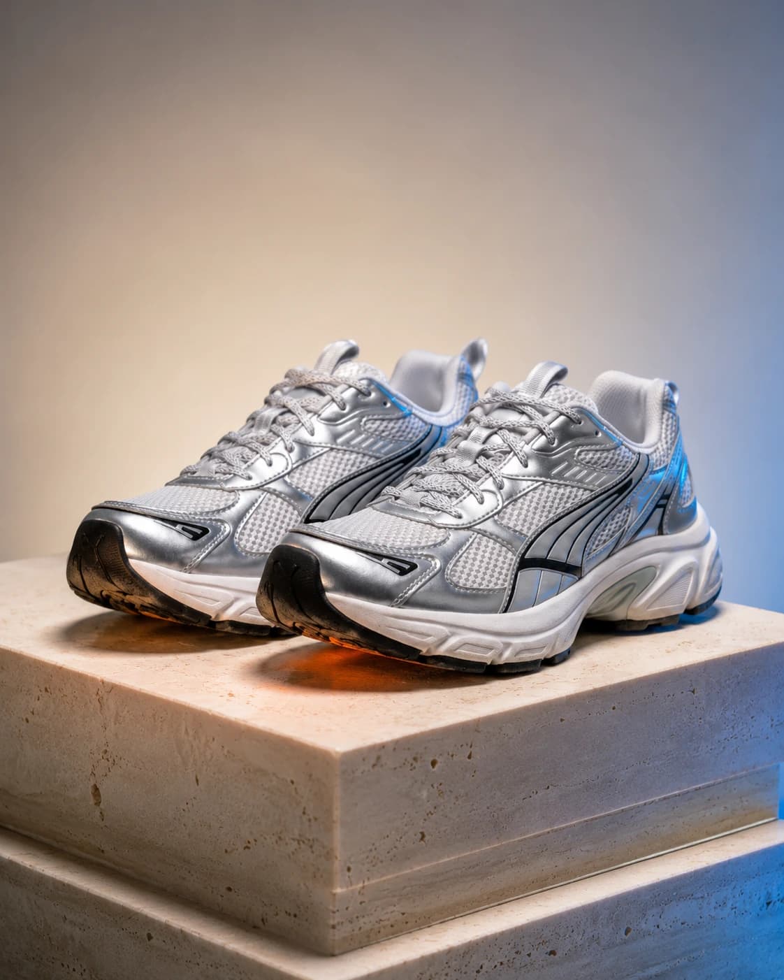 Luxury studio photoshoot of gray technical sneakers on an ivory plinth